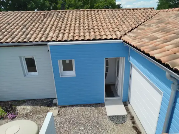 Extension bardée en clins bois bleu, couverture et bardage en Vendée (85) par MIP Menuiserie